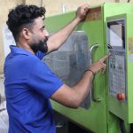 Factory worker operating machinery, showcasing industrial work in Karachi, Pakistan.